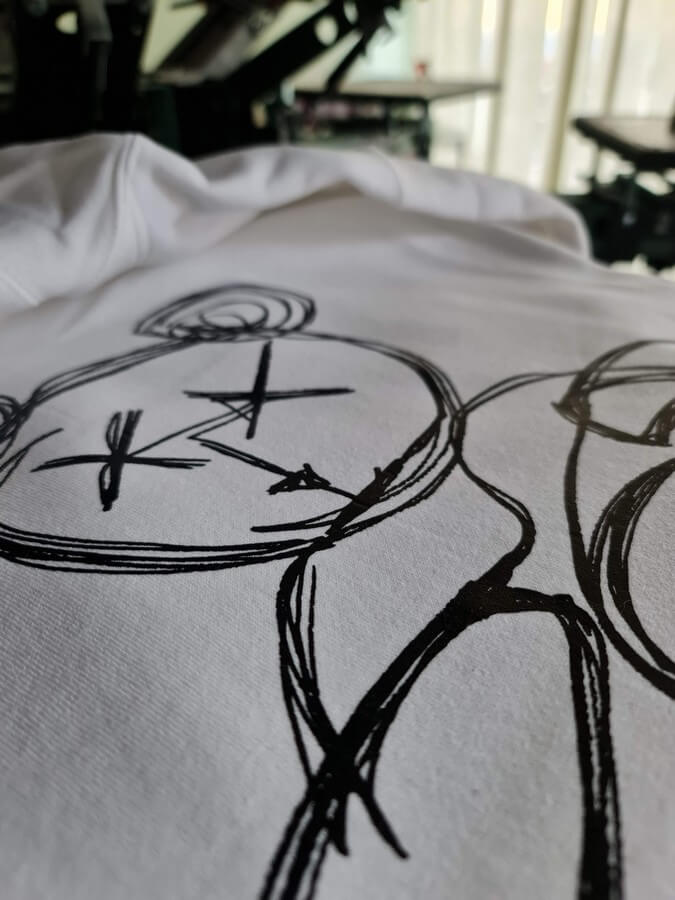 Single-colour A3-size screen print on the back of a white hoodie
